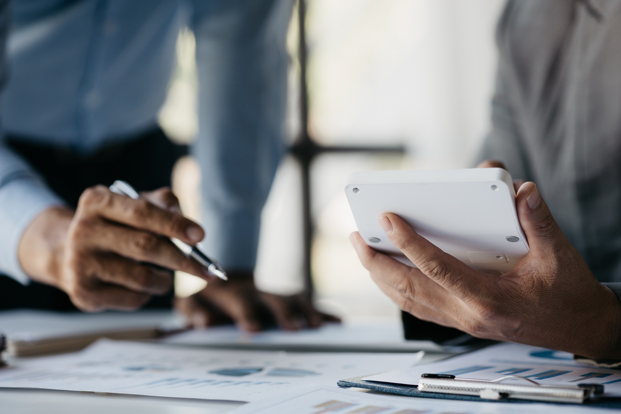 Business man using a white calculator, a financial businessman examining.