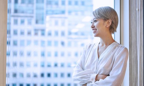 Portrait of businesswoman looking out of window smiling